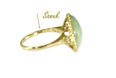 This is a show stopping 14k Gold Jade Ring by well known Jade Jewelry Mfg Sanuk. This gorgeous ring c1994, is designed in a true Victorian Style. It is a size 8 and can be resized to perfection by your local jeweler. The Jade gemstone is large and in perfect condition. The oval cabochon measures 17mm X 13mm X 4.5mm for a 8.06 carat weight. The setting and band are crafted in highly polished 14k gold. We have safely tested and it is guaranteed to be at least 14k gold. The setting a rope edge whic Luxury 14k Stamped Opal Ring For Formal Occasions, Formal Yellow Gold Halo Ring Stamped 14k, Formal Yellow Gold Hallmarked Halo Ring, Collectible Yellow Gold Rings With Halo Setting, Classic Opal Ring With Halo Setting For Formal Occasions, Classic 14k Stamped Round Halo Ring, Classic 14k Stamped Halo Ring, Formal 14k Gold Stamped Halo Ring, Formal 14k Gold Halo Ring Stamped 14k