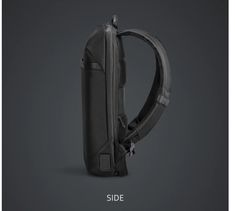 the back side of a black backpack on a dark background with text that reads, side