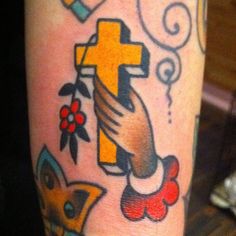 a close up of a person's leg with tattoos on it and a cross