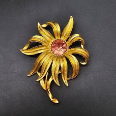 This vintage Trifari brooch features a gold tone flower with a pink rhinestone in the center and measures 2.5" x 2". It is signed Trifari Trifari Brooch, Trifari Jewelry, Vintage Trifari, Pink Rhinestones, Vintage Costume Jewelry, Flower Brooch, Vintage Costumes, Kingston, Costume Jewelry