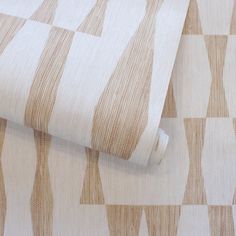 an upholstered wallpaper with wavy lines on it's surface, in beige and white