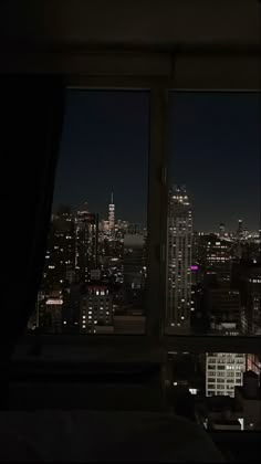 a view of the city at night from a hotel room window