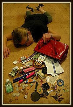 a woman laying on the floor surrounded by various items