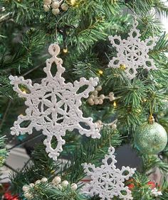 an ornament hanging from the christmas tree with snowflakes and ornaments around it