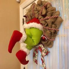 a wreath on the front door decorated with christmas stockings and santa's helpers