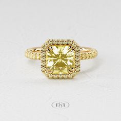 a yellow diamond ring with two rows of diamonds around the band and an halo setting