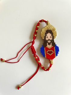 a beaded bracelet with a man wearing a red shirt and gold beads on it