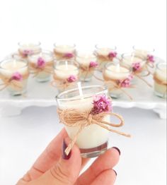 a hand holding a small glass filled with candles