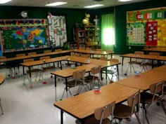 an empty classroom with many desks and chairs in front of the chalkboard on the wall