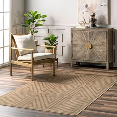 a living room area with a chair, sideboard and potted plant on the floor