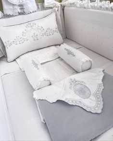 a bed with white sheets and pillows on top of it