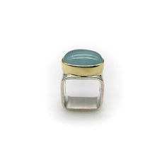 This is part of Chairish’s Fine Jewelry assortment.  Sleek and sculptural, this 18k gold and sterling silver ring is a contemporary piece with a modern feel. Designed by Gabriel Ofiesh, the ring features an oval aquamarine cabochon in an 18k gold bezel, set into a square sterling silver band. The aquamarine is a beautiful glacial blue, stunning alongside the sterling silver. The yellow gold bezel outlines the aquamarine, beautifully defining its shape against the cool colours of the ring. The ba Modern Oval Wide Band Ring For Formal Occasions, Contemporary Oval Rings For Formal Occasions, Modern Polished Emerald Open Ring, Modern Polished Moonstone Ring For Formal Occasions, Modern Moonstone Ring With Polished Finish For Formal Occasions, Contemporary Hallmarked Rings For Formal Occasions, Modern Polished Moonstone Ring For Anniversary, Modern Moonstone Ring With Polished Finish For Anniversary, Modern Open Moonstone Ring For Anniversary