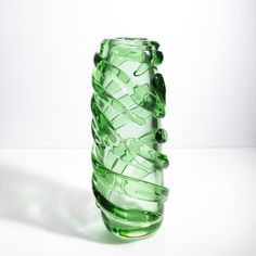 a green glass vase sitting on top of a table