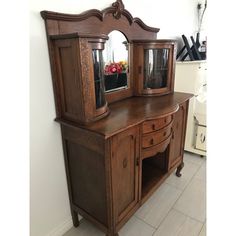 a wooden dresser with two mirrors on top of it