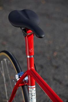 a red bike with a black seat on it