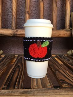 a coffee cup sleeve with a knitted apple on it