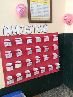 a red bulletin board with cups on it