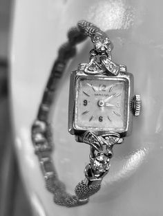 Vintage Art Deco 14k White Gold Hamilton Watch with genuine diamond accents. The watch is 14k gold with diamonds.  There are two larger round brilliant diamonds that measure 3.5mm in diameter and four smaller diamonds that are 1.5mm in diameter.  Total carat weight of the diamonds is approximately 0.42 calculated by measurements.  They are round brilliant cut and nice quality in the range of SI1 clarity and H/I color.   The watch face and bezel are solid 14k white gold and stamped.  The band is White Gold Diamond Watch With Single Cut Diamonds, Elegant White Gold Diamond Watch With Brilliant Cut, Elegant Platinum Watch With Diamond Accents, Elegant Platinum Watches With Diamond Accents, Elegant Platinum Diamond Watch With Accents, Elegant Diamond White Watch With Brilliant Cut, Elegant White Gold Diamond Watch With Diamond Accents, Silver Diamond Watch For Evening, Elegant White Gold Diamond Watch With Accents