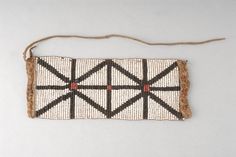 a piece of woven material with brown and black lines on the side, hanging from a string