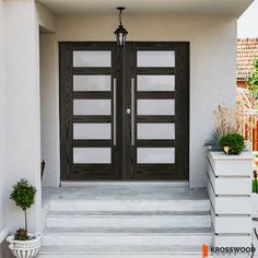 the front entrance to a house with two double doors