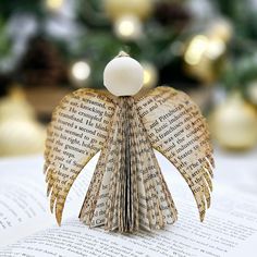 an origami angel sitting on top of a book