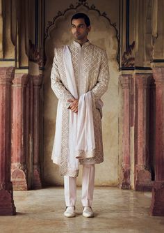 Radiate sophistication in this blush raw silk sherwani, paired with a cotton silk kurta and trouser, and embroidered in rose gold kasab with tonal dabka, beads, and crystals. Complete the look with a worked belt and stole. Pink Sherwani, Modern Groom, Indian Wedding Wear, Silk Kurta, Sherwani, Modern Bride, Wedding Wear, Embroidered Silk, Pink Fabric