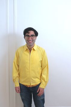 "This vibrant yellow windbreaker/ track jacket from \"Arnold Palmer\" is a tag size \"42\". This jacket is simple with a center front metal zipper and pockets, the style also sometimes referred to as an Eisenhower jacket.  The jacket has raglan sleeves and a small collar tab. It is not lined and is cut in the \"members only\"  style. Although it has a men's size tag, it can easily be worn by a man or woman.  DETAILS: Era: 1960's Tags: Arnold Palmer Tag size: 42 Color: Yellow  Material: cotton canvas Closure: zipper center front  CONDITION: It is in good condition there are no rips or tears. The zipper is fully functional The jacket has a few minor fabric aging spots MEASUREMENTS: Chest: 46\" Length: 26\" Sleeve: 26\" Approximately a modern medium/ large  PLEASE NOTE: vintage sizes differ f Eisenhower Jacket, Yellow Windbreaker, Arnold Palmer, Members Only, Metal Zipper, Track Jacket, Track Jackets, Vintage Tags, Raglan Sleeve