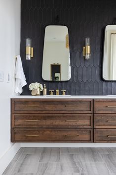 a bathroom vanity with two mirrors above it