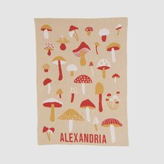 a towel with mushrooms on it and the words alexandria written in red, yellow and white