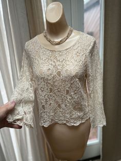 "Just a cute lace pullover top to wear with jeans or cargo pants or with a long flowing gauze maxi skirt with tie strings at waist. Size is Small. Not a stretchy lace. Unique dusty beige color, sort of like tablecloth lace. Pullover style with a single button loop closure at back neck. Scalloped and sort of 'curly' edges at the bottom and ends of sleeves. Obviously there is some 'see through' by way of the meshy lace. You can wear a simple silk camisole underneath or even try something in black Beige Lace Top, Curly Edges, Look Beige, Beige Blouse, Cropped Blouse, Silk Camisole, Lace Short, Asymmetrical Tops, Crop Blouse