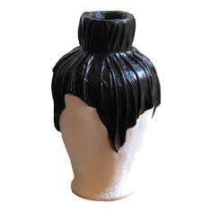 a white mannequin head with black leather hair on it's back end