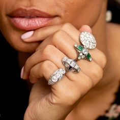 The Story A beautiful Art Deco dinner ring from the 1920s. At center is a half carat old mine cut diamond. Two square cut emeralds are bezel set above and below, each measuring 5 x 4.5 mm. Accenting the piece are eight old mine cut diamonds, each 0.07- 0.08 carats, giving the ring a total diamond weight of approximately 1.12 carats. The back is completely open allowing the diamonds to sparkle bright and the emeralds to pop with color. Measuring just under an inch tall, the shape and size has a substantial feel. The 18k white gold design allows for open work and millegrain detailing throughout. Worn as an engagement ring or a cocktail ring, this beautiful piece is sure to stop you in your tracks. The Specs Style Number: R2533 Antique, circa 1920s 18 karat white gold 2 square cut emeralds, e Art Deco Jewelry With Rose Cut Round Diamonds, Art Deco Diamond Jewelry With Gemstone, Art Deco Rose Cut Round Diamond Jewelry, Art Deco Emerald Cut Diamond Jewelry, Art Deco Emerald Ring With 17 Jewels, Art Deco Diamond Ring With 17 Jewels, Art Deco Diamond White Jewelry With Gemstone, Art Deco Diamond Rings With 17 Jewels, Art Deco Diamond White Gemstone Jewelry