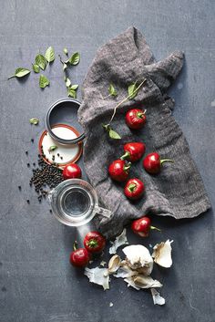 tomatoes, garlic and other ingredients are on the table next to a cloth with some type of sauce in it