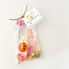 an assortment of toothbrushes in a plastic bag on a white surface with a thank card