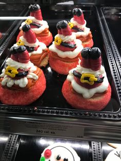 there are many cupcakes with santa hats on them in the display case at the store