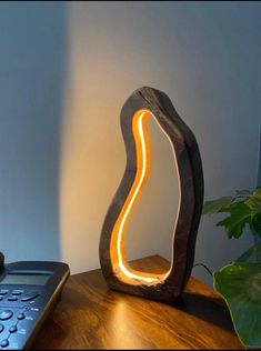 a lamp that is sitting on top of a wooden table next to a remote control