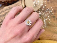 "X-mas delivery last order dates: UK Standard (1st class signed) 14th Dec, UK Express (Special Delivery) 20th Dec, ROW (Tracked & Signed) 7th Dec Daisy Ring This beautiful flower ring is crafted from sterling silver and features a 24ct yellow gold accent centre. The flower is set onto a simple, delicate band ring with a flat edge, making it really comfortable to wear.  Each ring will be handmade to order and can be made in any size, including UK half sizes, American and European sizes. Select your size when ordering or choose \"bespoke size\" and send a message with your size at checkout. If you need help with your ring size please get in touch. Materials: 925 Sterling Silver, matte finish with 24ct yellow gold accent (fused to the surface) Size: Daisy approx 13mm diameter, band ring 1mm w Daisy Ring, Ring Flower, Zierlicher Ring, Nature Ring, Floral Ring, Silver Band Ring, Handmade Gold, Curated Gifts, Delicate Flower