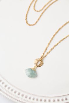 Indulge in the radiance of Dreams & Flowers with our beautifully crafted aquamarine focal necklace. An elegant addition to any outfit. Matte Gold Plated Brass (lead and nickel free) Aquamarine 24.5-26.5", adjustable with matte gold plated brass lobster claw clasp We hand select our natural materials, thus there may be slight variations in color and/or size that will not detract from the overall aesthetic Our unique handcrafted designer jewelry for women is made in America, with each design creat Elegant Round Amazonite Necklace, Elegant Everyday Amazonite Jewelry, Elegant Aquamarine Faceted Necklace, Elegant Amazonite Necklace For Gift, Gold Aquamarine Pendant Necklace, Elegant Gold Amazonite Necklace, Blue Faceted Amazonite Jewelry, Faceted Blue Amazonite Jewelry, Elegant Blue Amazonite Jewelry