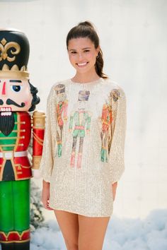 Introducing our NUTCRACKER LONG-SLEEVE GOLD SEQUIN DRESS, the perfect addition to your holiday wardrobe. This stunning long-sleeve dress features a gorgeous gold sequin design that is sure to catch everyone's eye. The cinched wrists add a touch of elegance while the nutcracker trio print adds a playful twist. 'Tis the season to shine! All orders are currently shipping within 14 business days. To receive item quicker, expedited shipping is available at checkout. Gold Long Sleeve Winter Dress, Gold Long Sleeve Dress For Winter, Long Sleeve Sequin Dress For Festive Winter Occasions, Long Sleeve Sequin Dress For Winter Festive Occasions, Long Sleeve Sequin Dress For Winter Festivities, Long Sleeve Christmas Celebration Dress, Christmas Celebration Dress With Long Sleeves, Christmas Celebration Long Sleeve Dress, Festive Long Sleeve Glamorous Sequin Dress