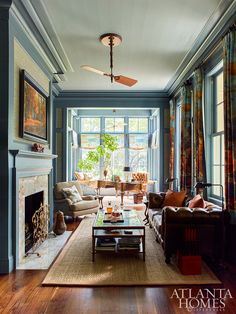 a living room filled with furniture and a fire place in front of a large window