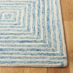 a blue and white area rug on the floor with wood floors in the foreground