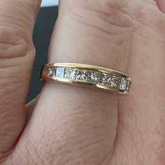 a woman's gold wedding band with princess cut diamonds on the inside of it