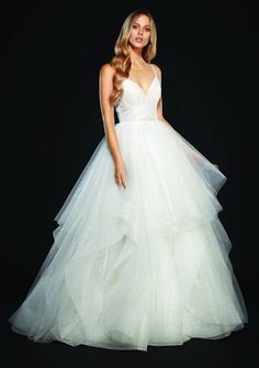 a woman in a wedding dress posing for the camera