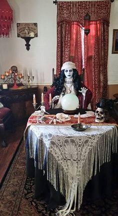 a creepy doll sitting at a table with candles