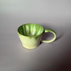 a green cup sitting on top of a table