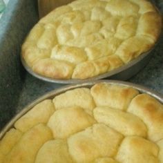 two pies sitting in pans on top of a counter