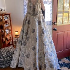 a woman taking a selfie in front of a door wearing a dress with flowers on it