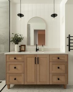 a bathroom with wooden cabinets and white walls