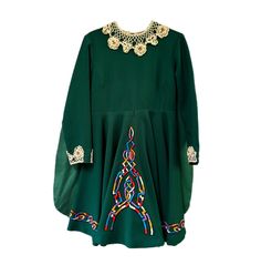 a green dress with embroidered details on it