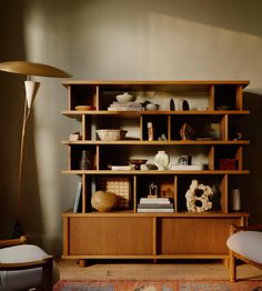 a living room with a large wooden shelf filled with books and knick knacks